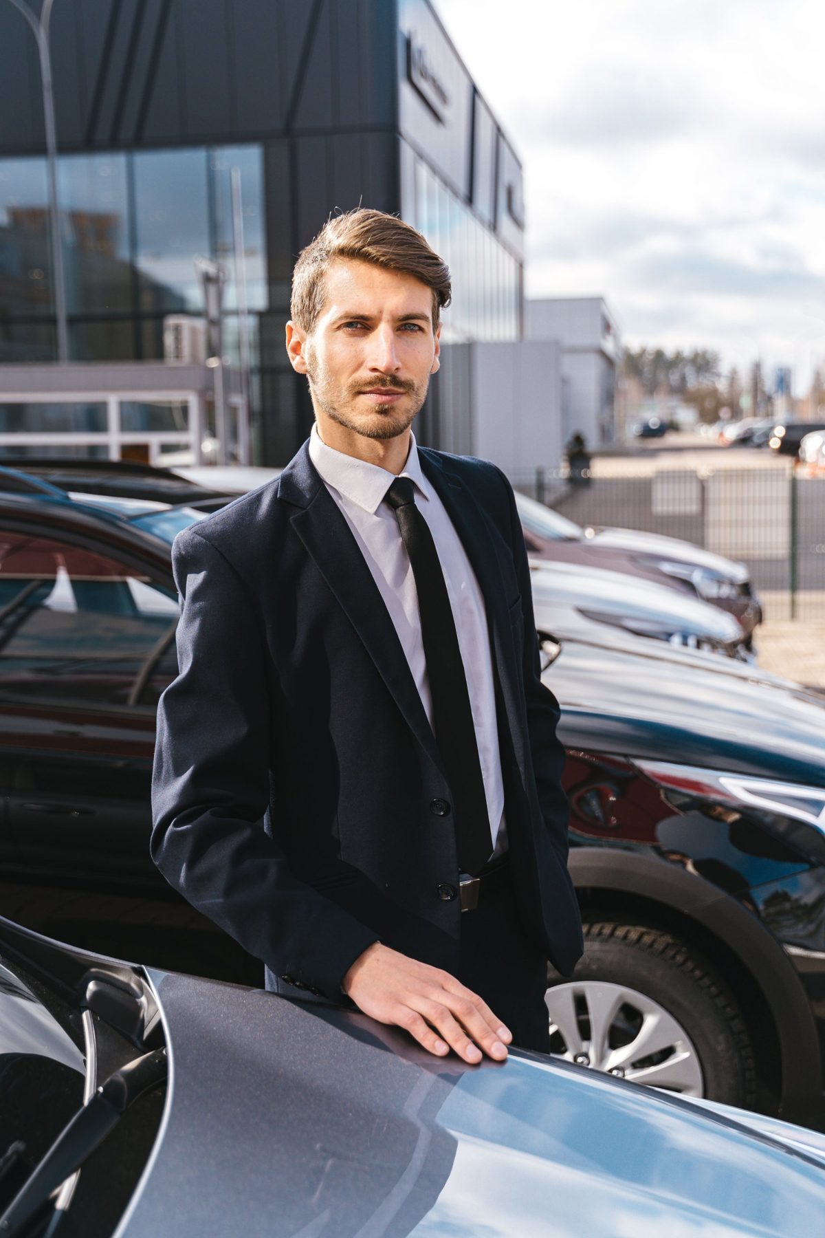 A car buyer standing on a dealer lot