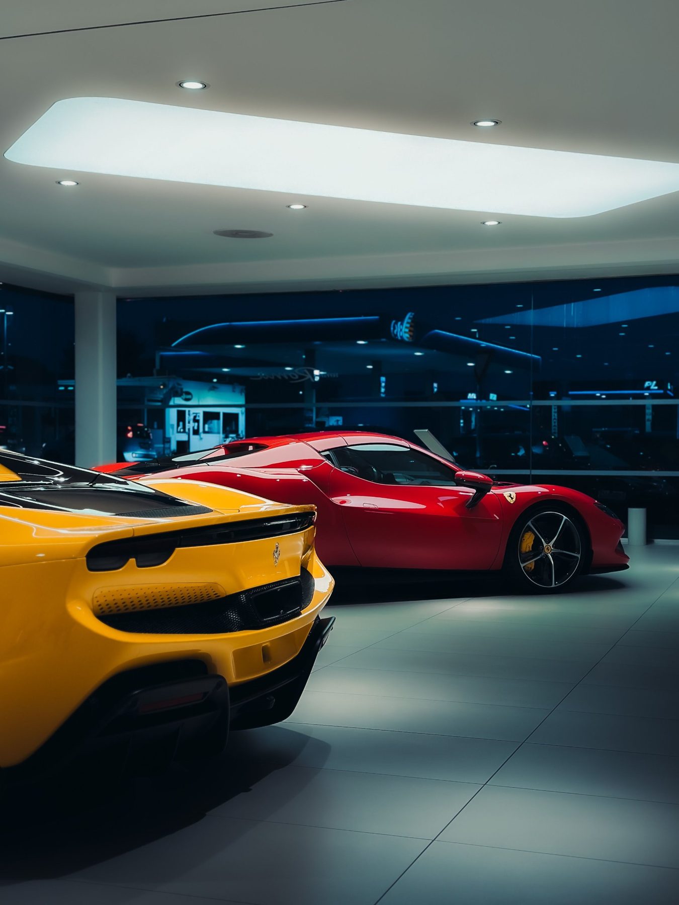 Cars on display in a dealership showroom at night